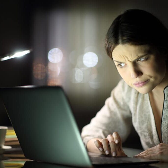 Suspicious woman checking laptop content in the night