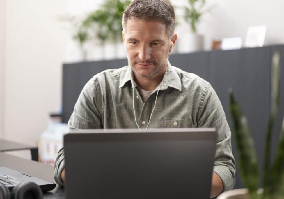 Businessman using laptop in office while having video conference.