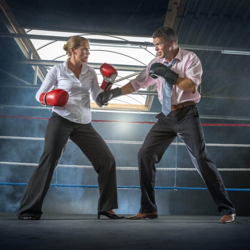 Business couple fighting in smokey boxing ring Couple woman punching boxing a man dispute conflict